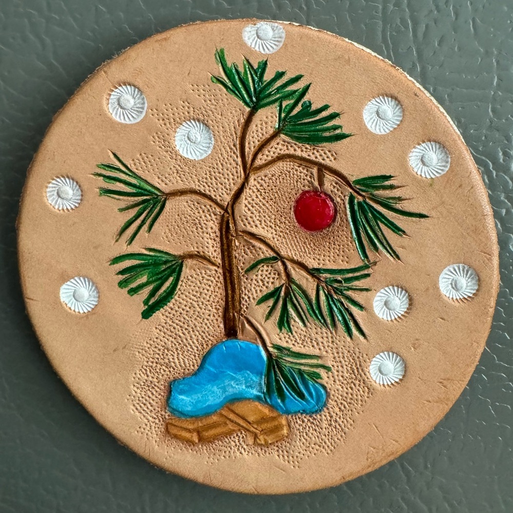 Handmade hand-carved little tree and snowflakes on leather magnet